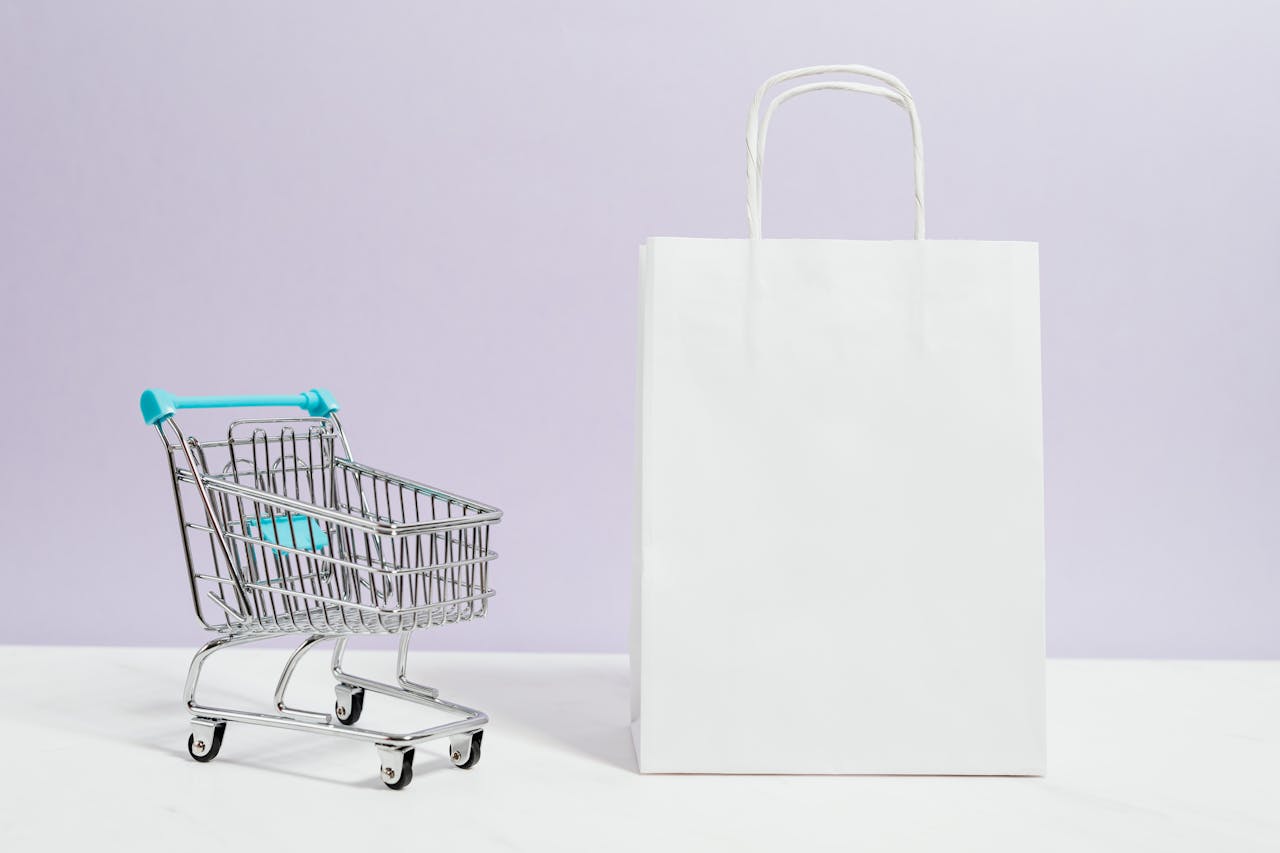 Crafting Captivating Headlines: Your awesome post title goes here Minimalist image of a white shopping bag and mini cart on a soft pastel background.