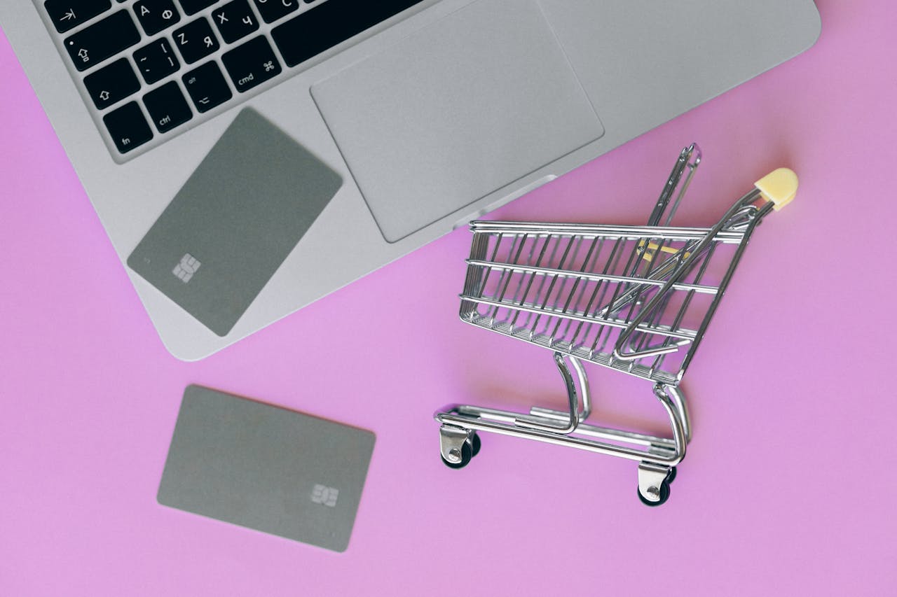 Mastering the First Impression: Your intriguing post title goes here A minimalist flat lay of a credit card, laptop, and miniature shopping cart.
